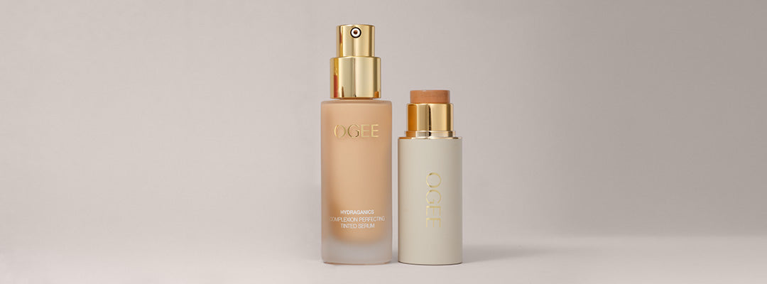 Two Ogee foundation products stand side by side, a glass pump bottle of Complexion Perfecting Tinted Serum and a Sculpted Complexion Foundation Stick.