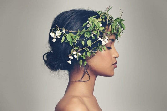 Profile of a dark hair, olive skinned woman with a flower crown on her head 